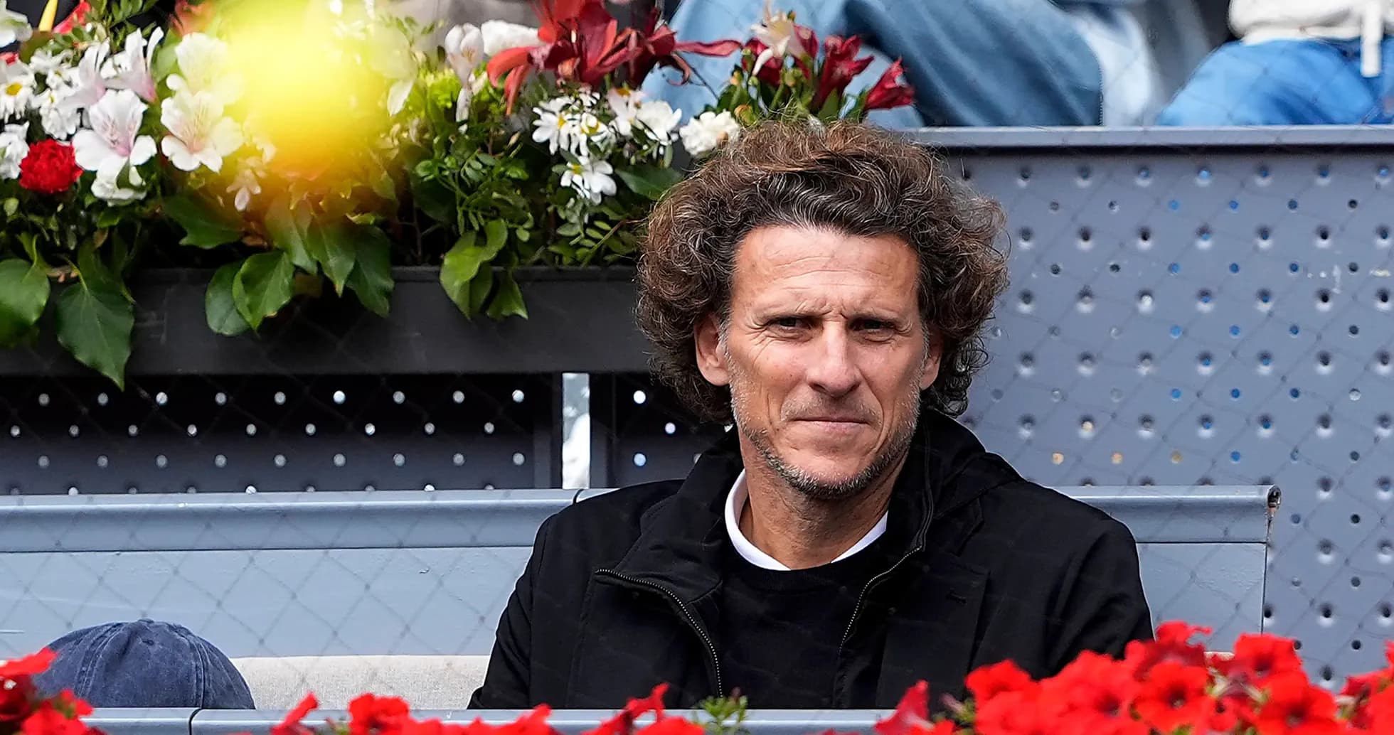 Man sitting among flowers at tennis match Man sitting among flowers at tennis match