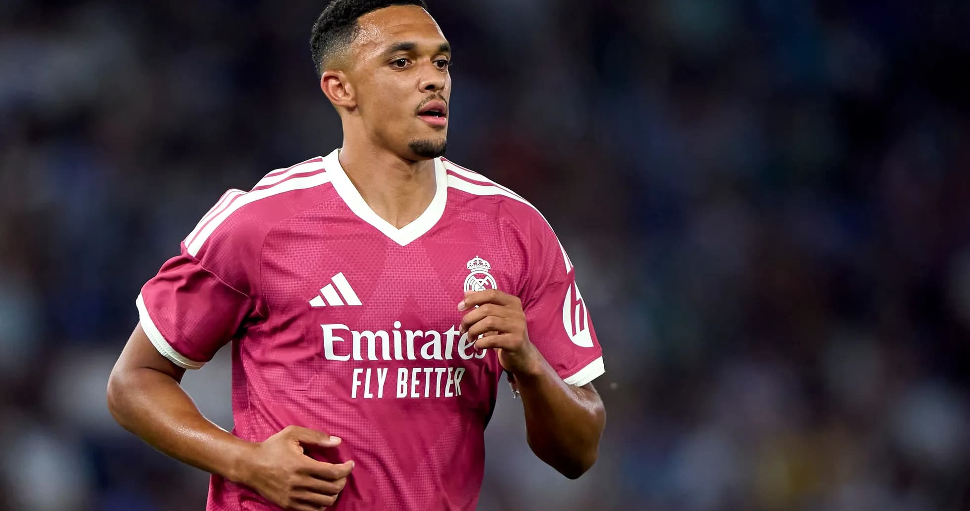 Player in pink Real Madrid jersey running on field Player in pink Real Madrid jersey running on field