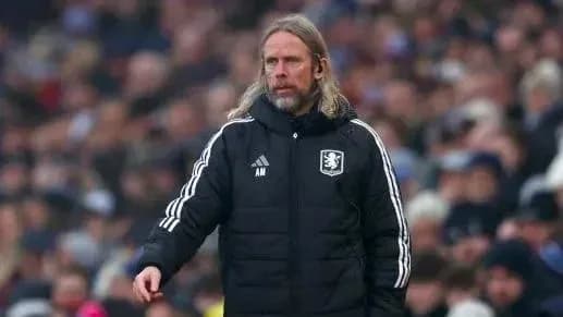 Coach wearing team jacket on sideline during match Coach wearing team jacket on sideline during match