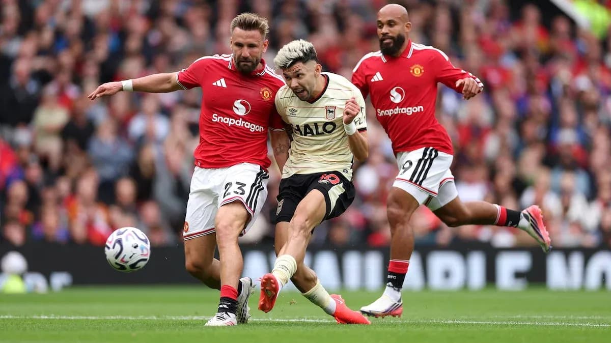 Manchester United players challenging Ipswich player for the ball Manchester United players challenging Ipswich player for the ball