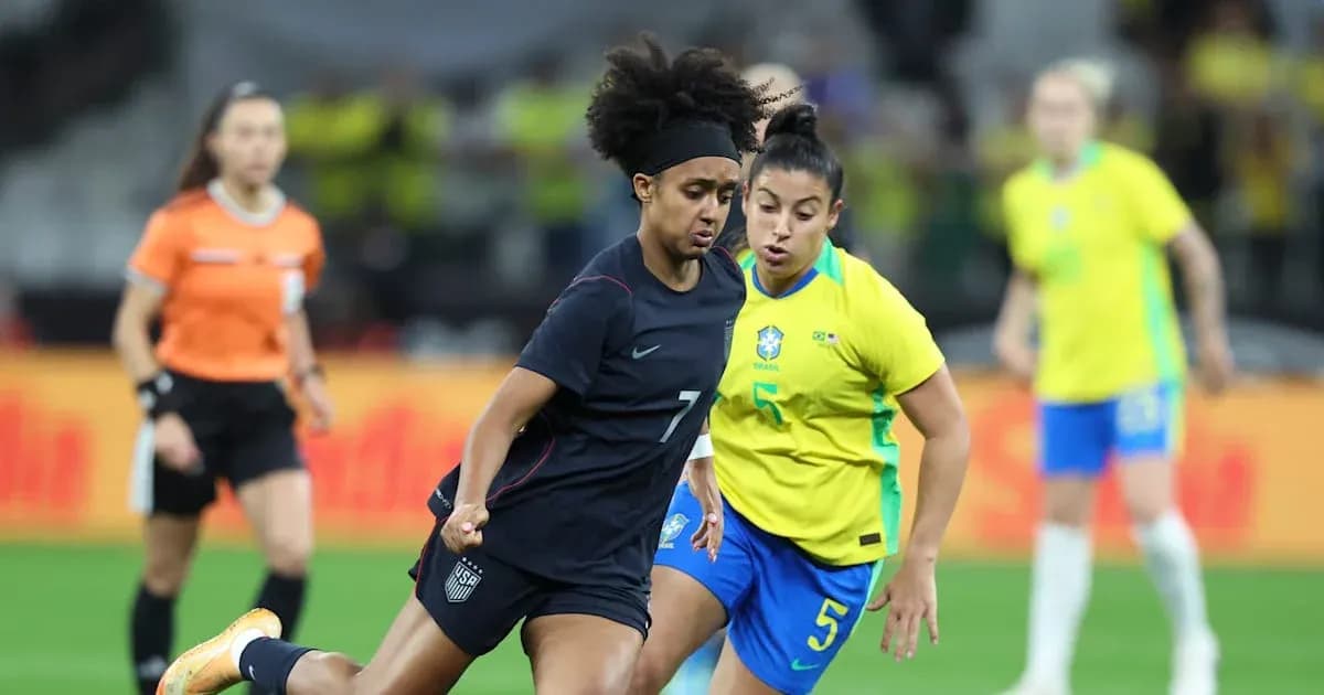 US player dribbling past Brazilian defender during match US player dribbling past Brazilian defender during match
