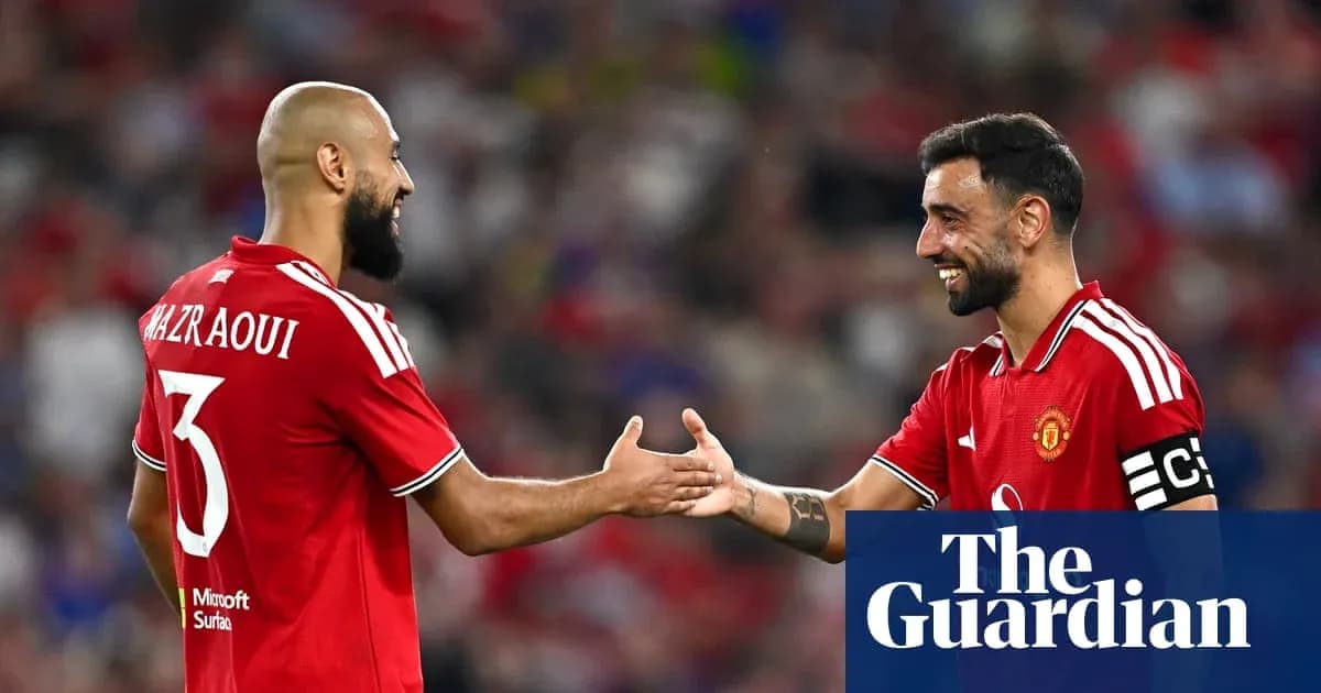 Two Manchester United players shaking hands on field Two Manchester United players shaking hands on field