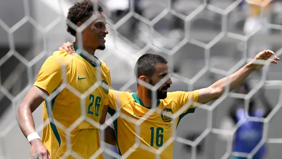 Two Australian players celebrating a goal together Two Australian players celebrating a goal together