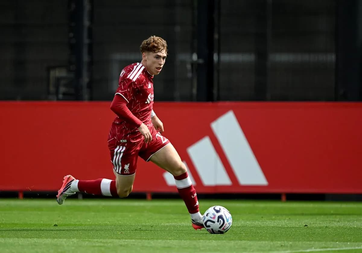 Player in red kit sprinting with soccer ball Player in red kit sprinting with soccer ball