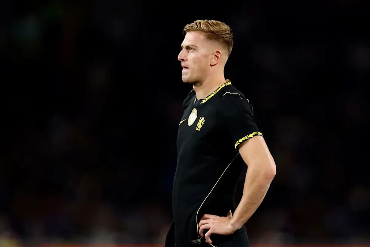 Player in black kit standing on the field Player in black kit standing on the field