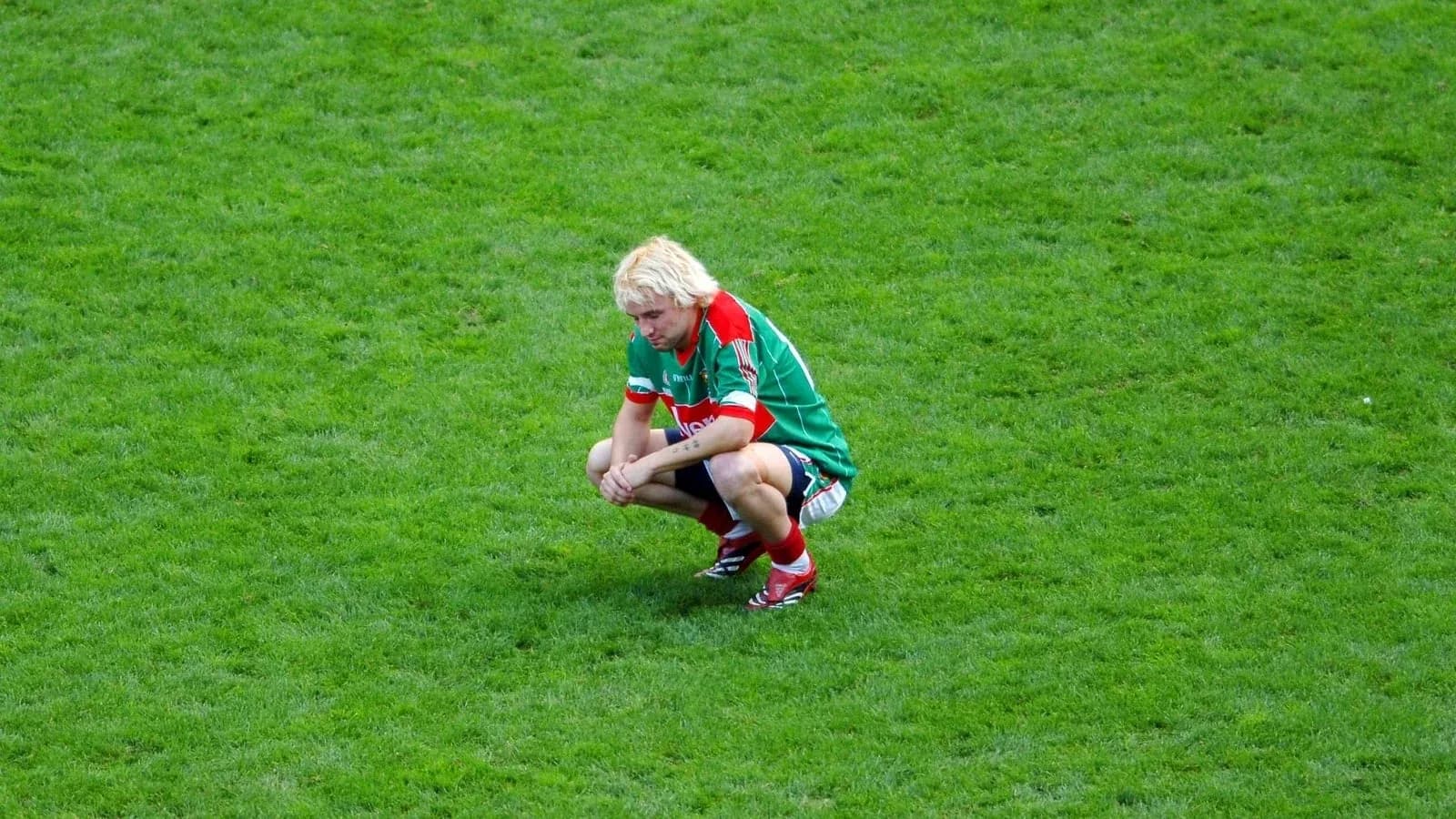 Player crouching on the field after a match Player crouching on the field after a match