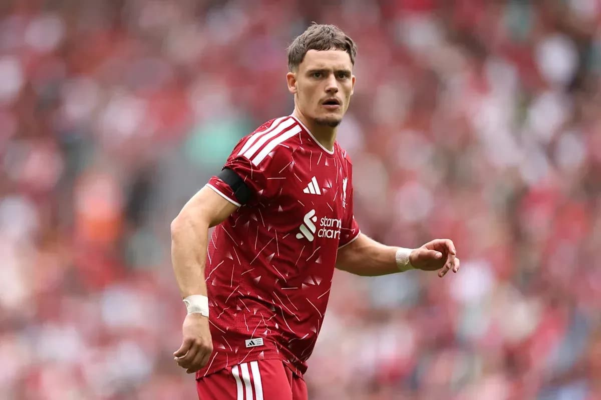 Player in red jersey on football pitch during match Player in red jersey on football pitch during match