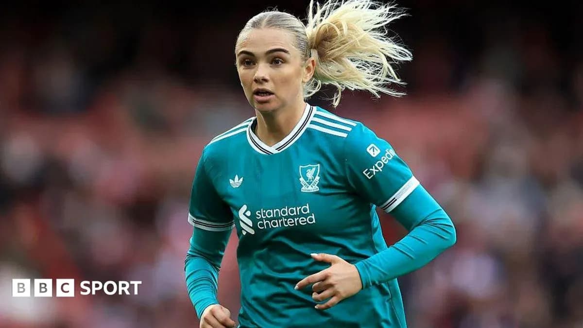 Player in teal Liverpool kit running on pitch Player in teal Liverpool kit running on pitch