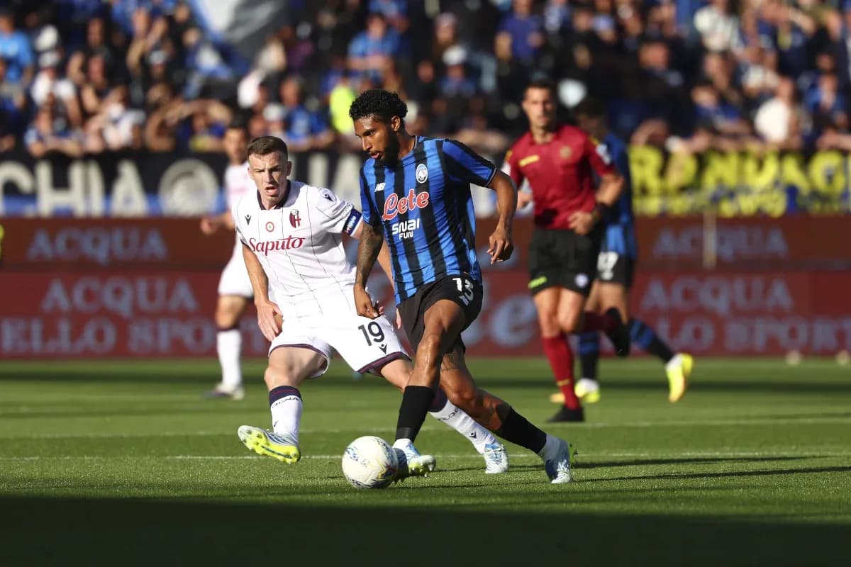 Atalanta player dribbling past Bologna opponent Atalanta player dribbling past Bologna opponent