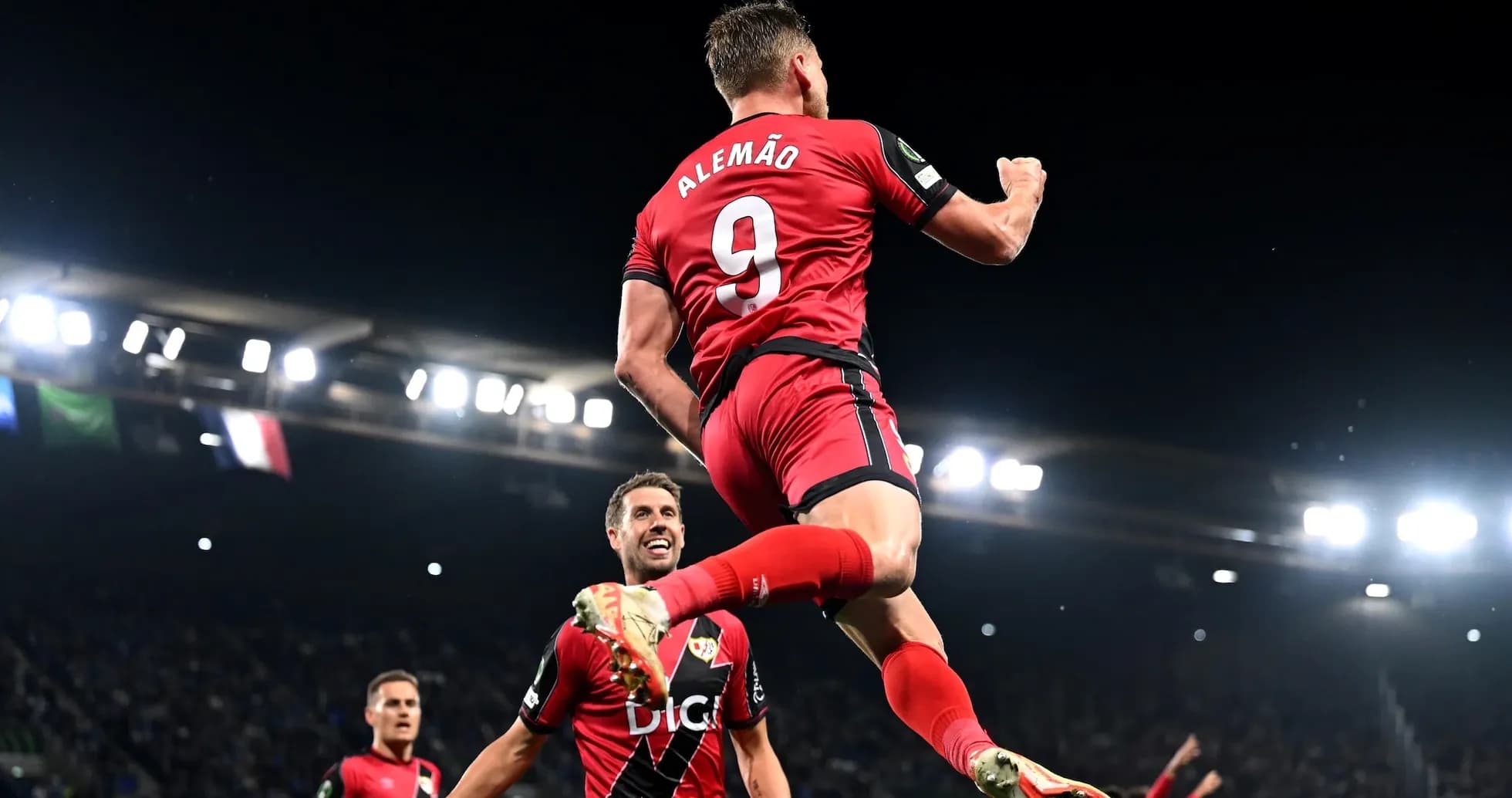Player celebrating a goal with teammates on field Player celebrating a goal with teammates on field