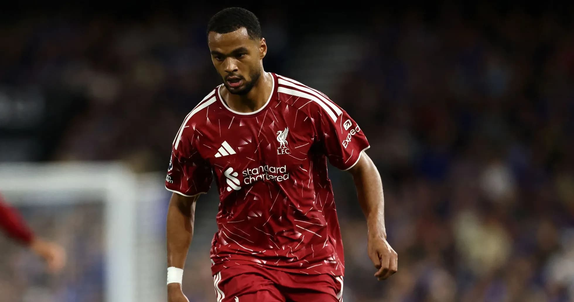 Player in Liverpool kit running on the field Player in Liverpool kit running on the field