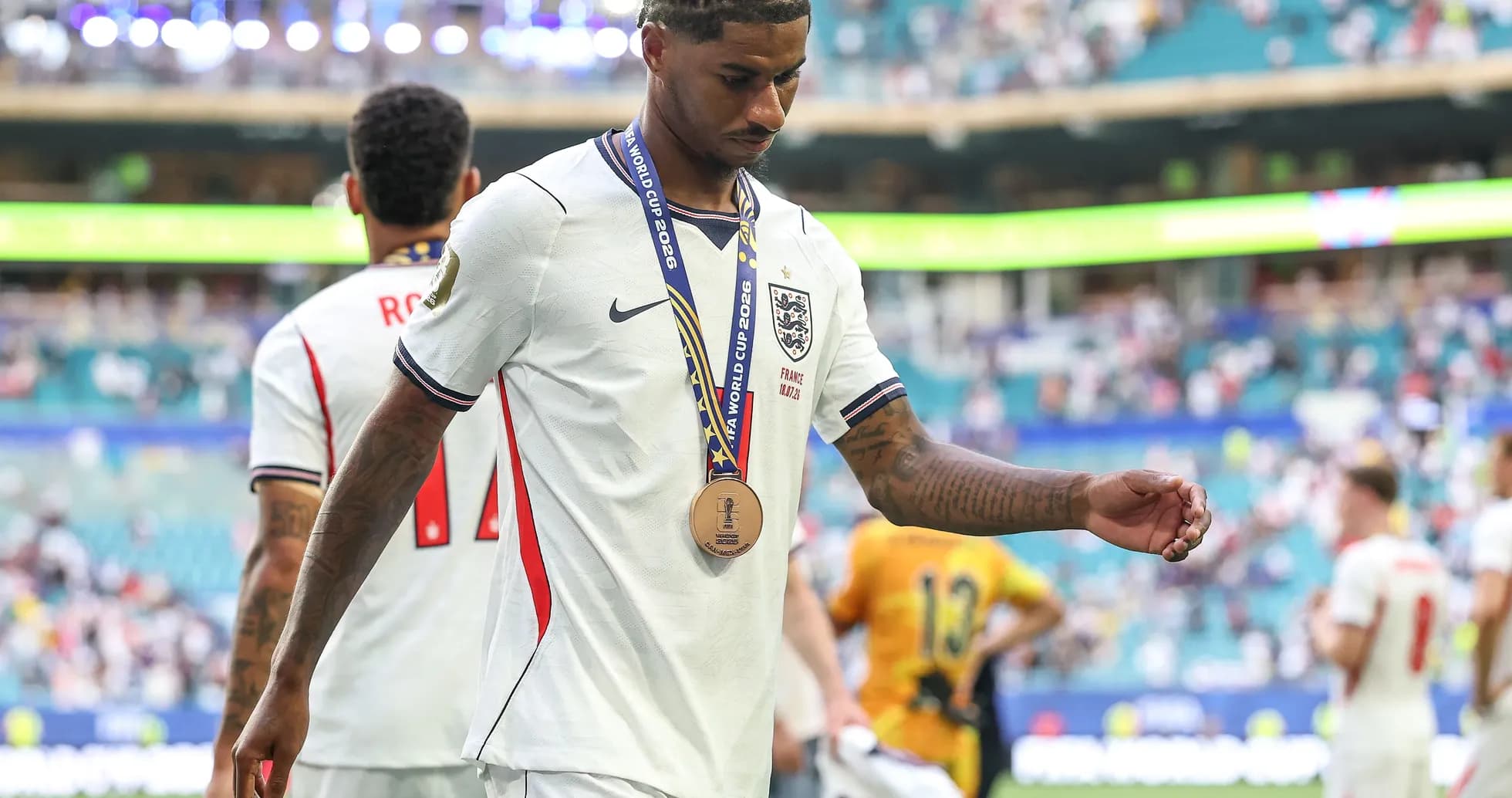 Player walking off field wearing a bronze medal Player walking off field wearing a bronze medal
