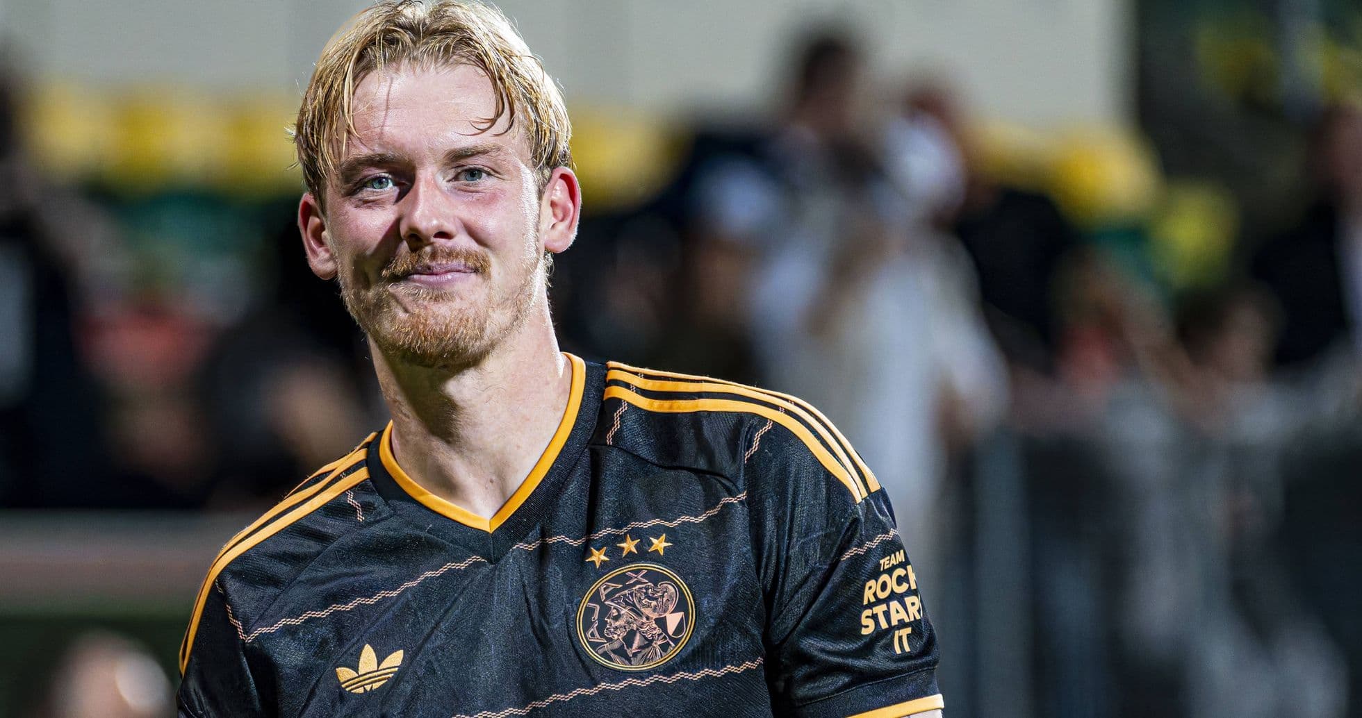 Player in Ajax jersey smiling at the camera Player in Ajax jersey smiling at the camera