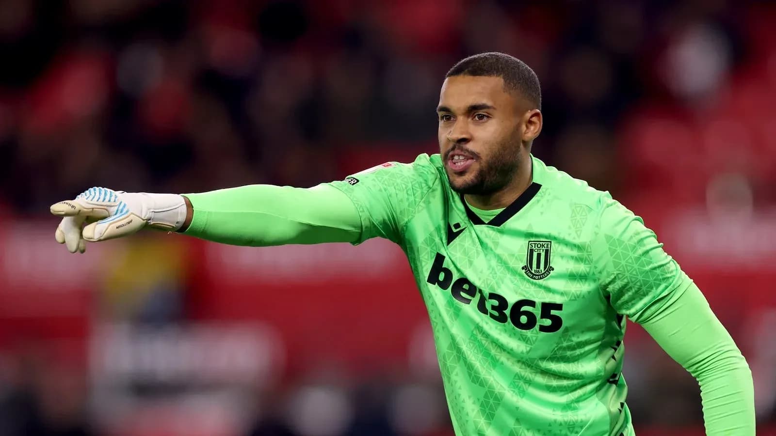 Goalkeeper in green kit directing teammates during match Goalkeeper in green kit directing teammates during match