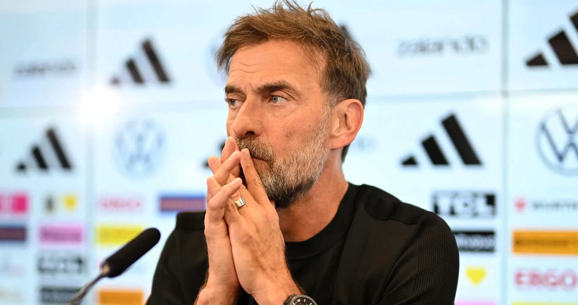 Manager speaking at press conference with logos behind Manager speaking at press conference with logos behind