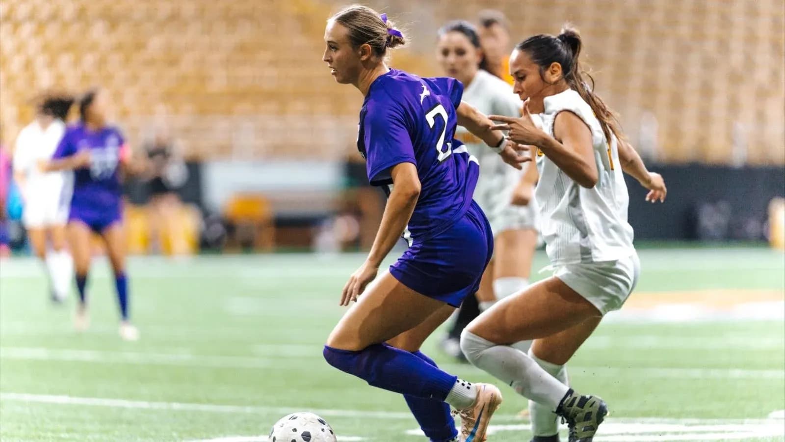 Two players competing for the ball in soccer match Two players competing for the ball in soccer match