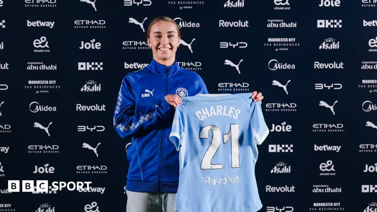 Player holding Manchester City jersey during signing event Player holding Manchester City jersey during signing event