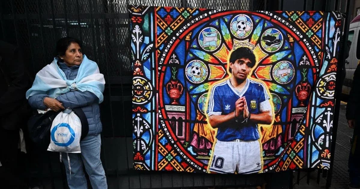 Woman standing beside mural of Diego Maradona Woman standing beside mural of Diego Maradona