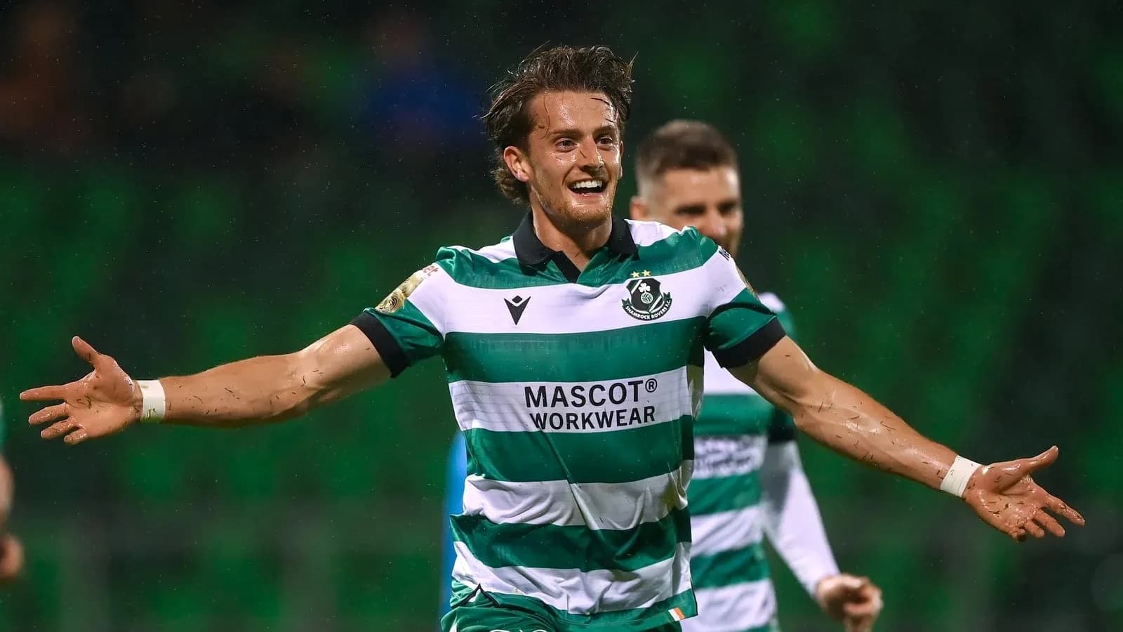 Player celebrating a goal in green and white uniform Player celebrating a goal in green and white uniform