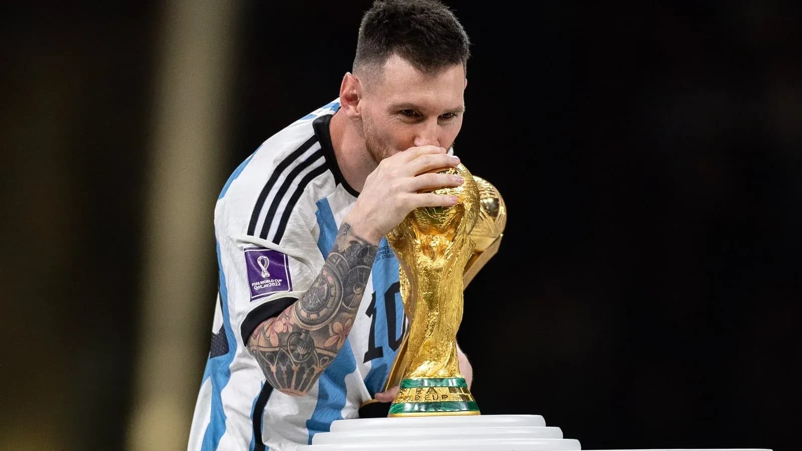 Player kissing FIFA World Cup trophy on podium Player kissing FIFA World Cup trophy on podium
