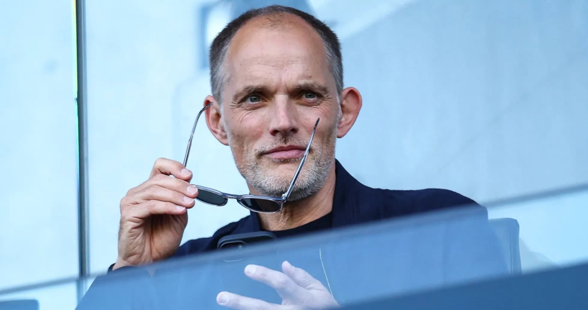 Man holding glasses while using a phone Man holding glasses while using a phone