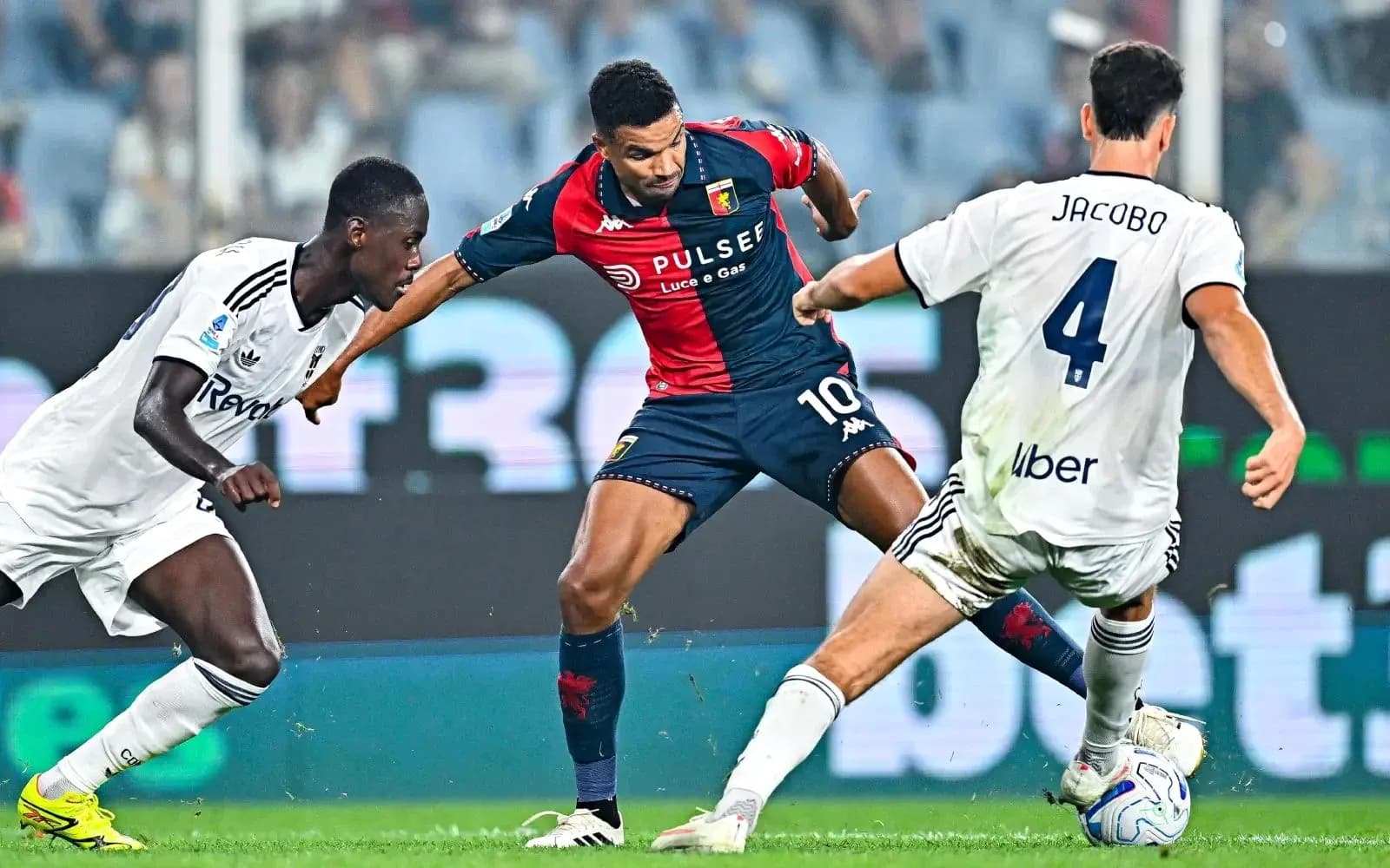 Genoa player dribbling against Como defenders Genoa player dribbling against Como defenders