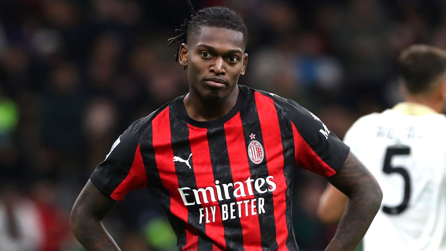 AC Milan player in red and black jersey on field AC Milan player in red and black jersey on field