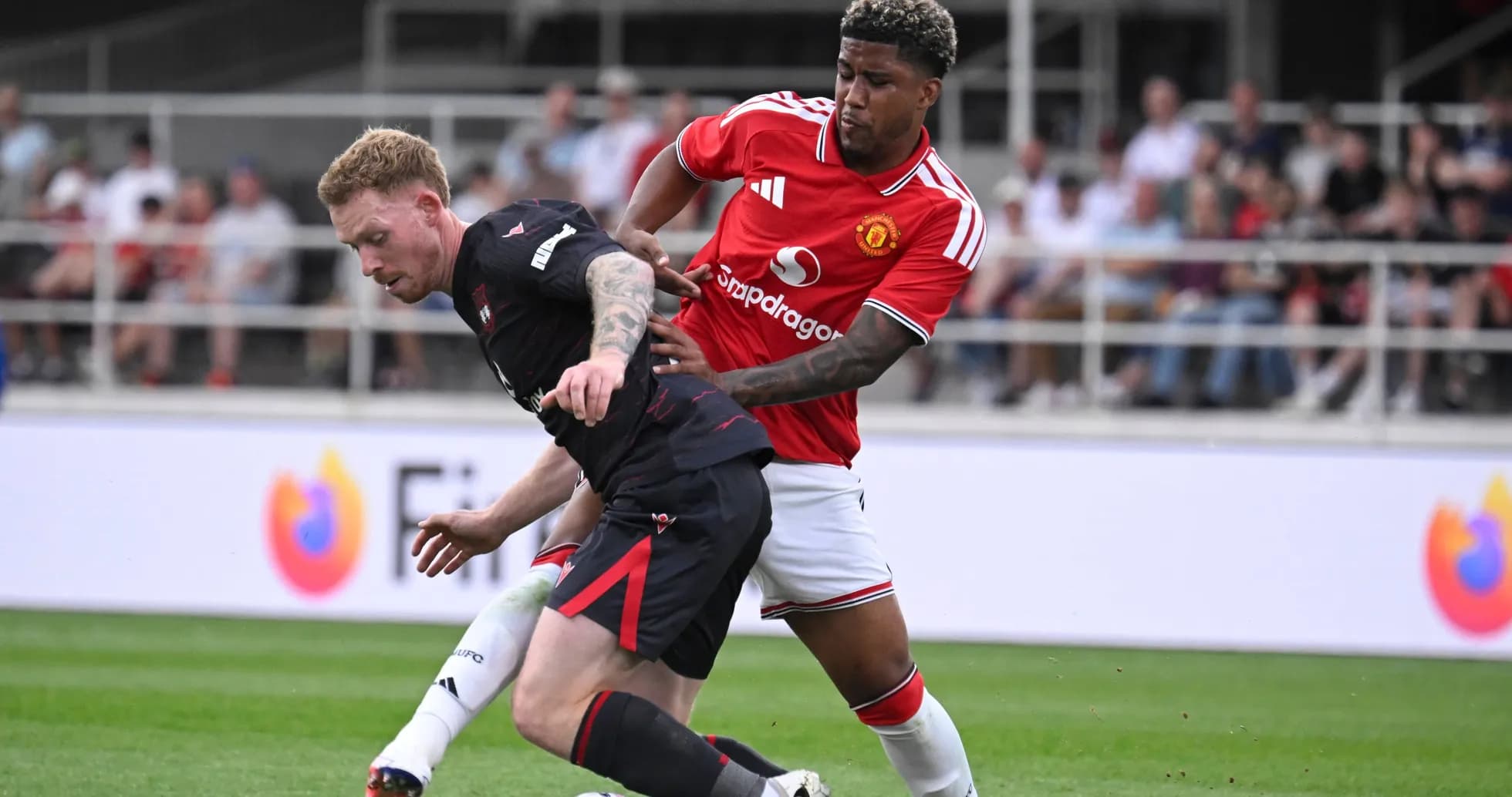 Player from Manchester United challenging opposing player Player from Manchester United challenging opposing player