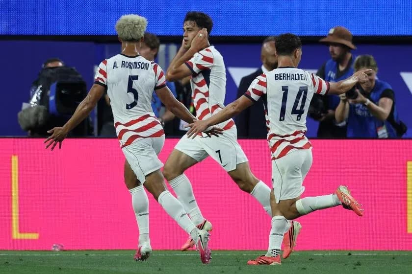 Three US players celebrating a goal on field Three US players celebrating a goal on field