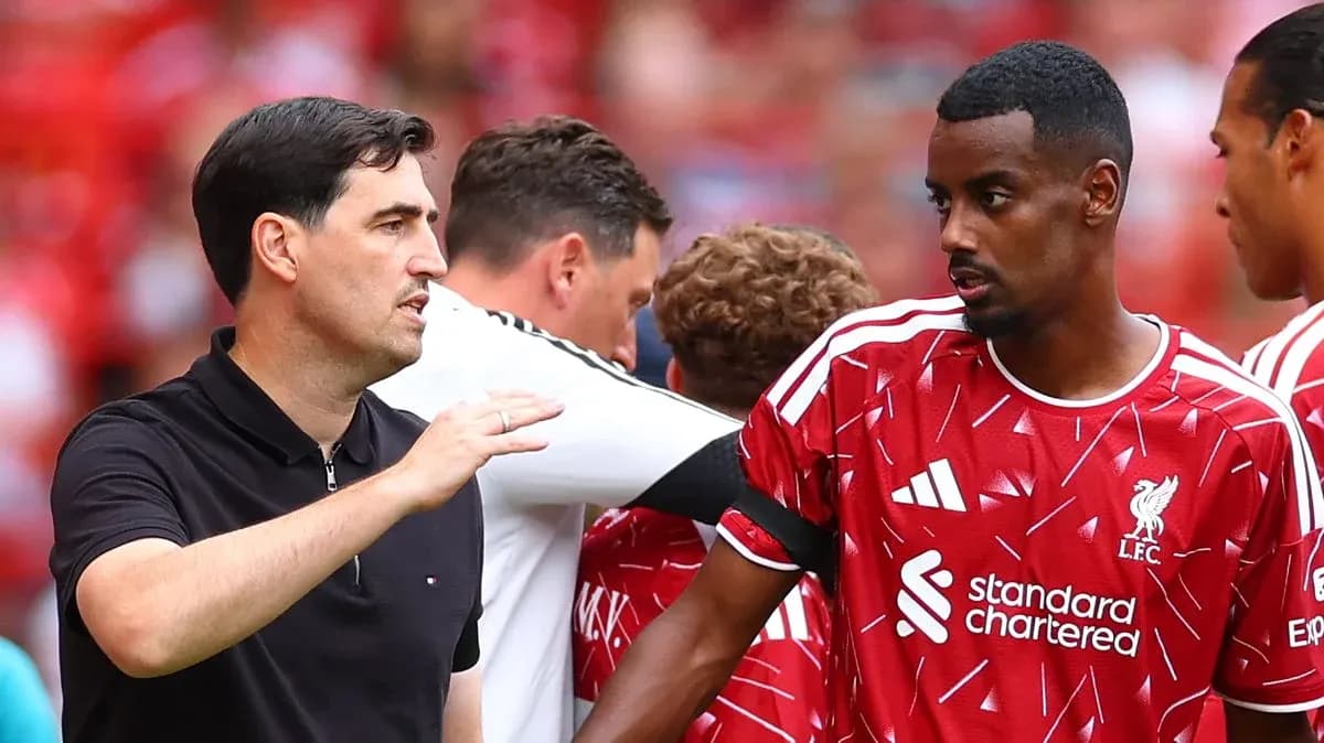 Coach discussing strategy with Liverpool player on sidelines Coach discussing strategy with Liverpool player on sidelines
