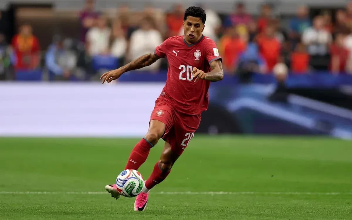 Player in red jersey dribbling ball on field Player in red jersey dribbling ball on field