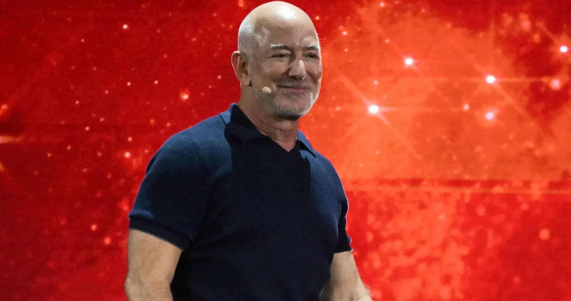 Person speaking on stage with red background Person speaking on stage with red background