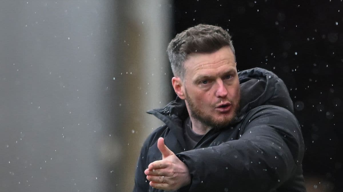 Manager gesturing during match in rainy conditions Manager gesturing during match in rainy conditions