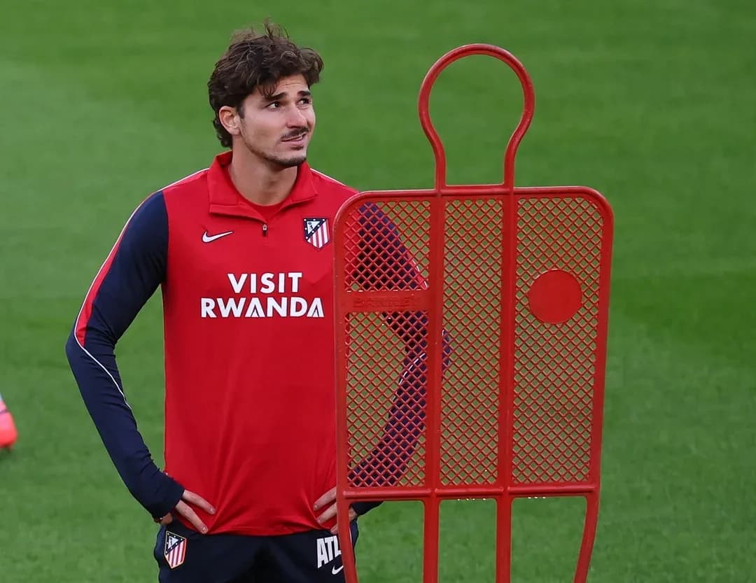 Player standing beside training dummy on field Player standing beside training dummy on field