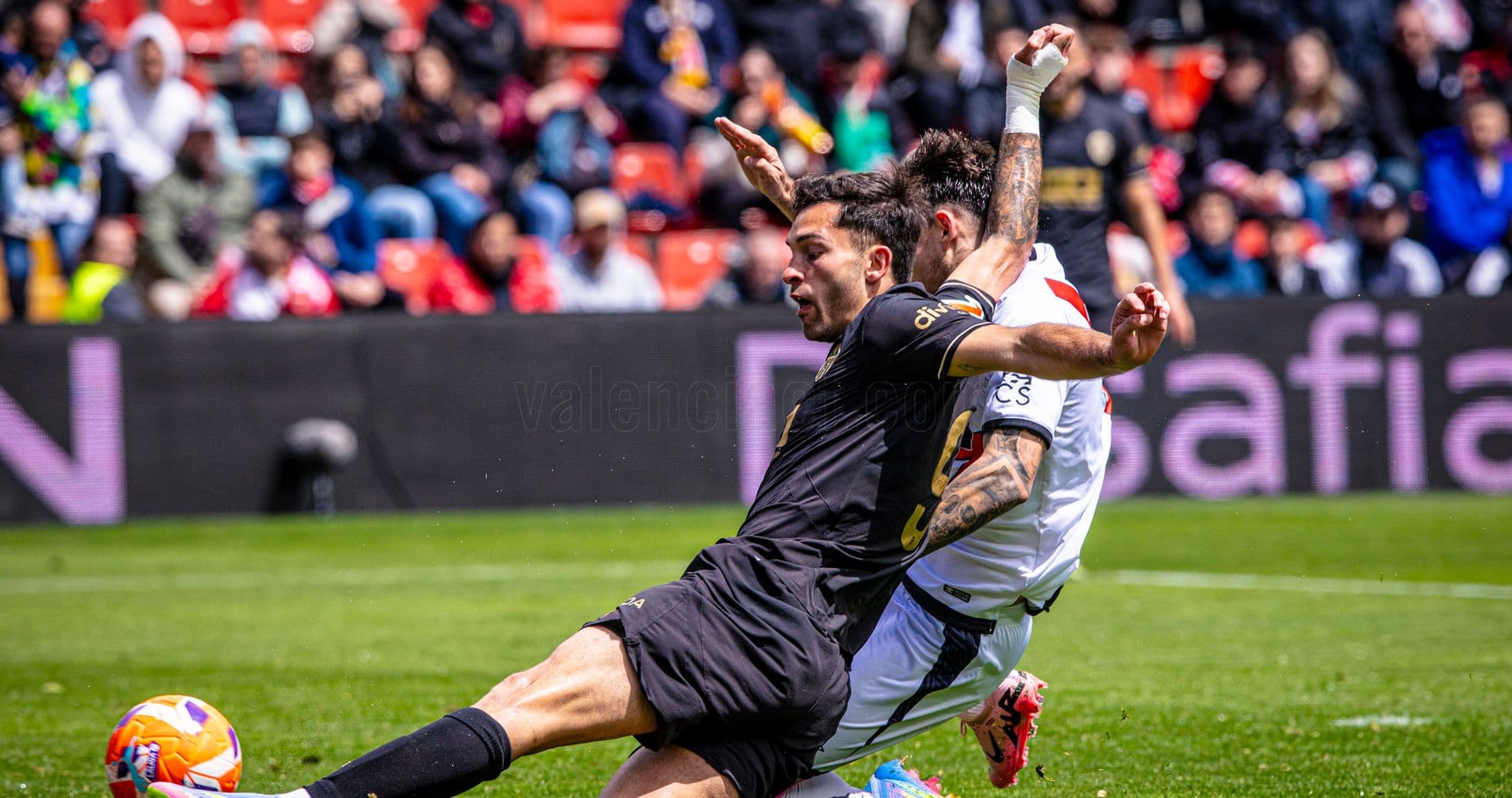 Valencia player tackling Rayo Vallecano opponent Valencia player tackling Rayo Vallecano opponent