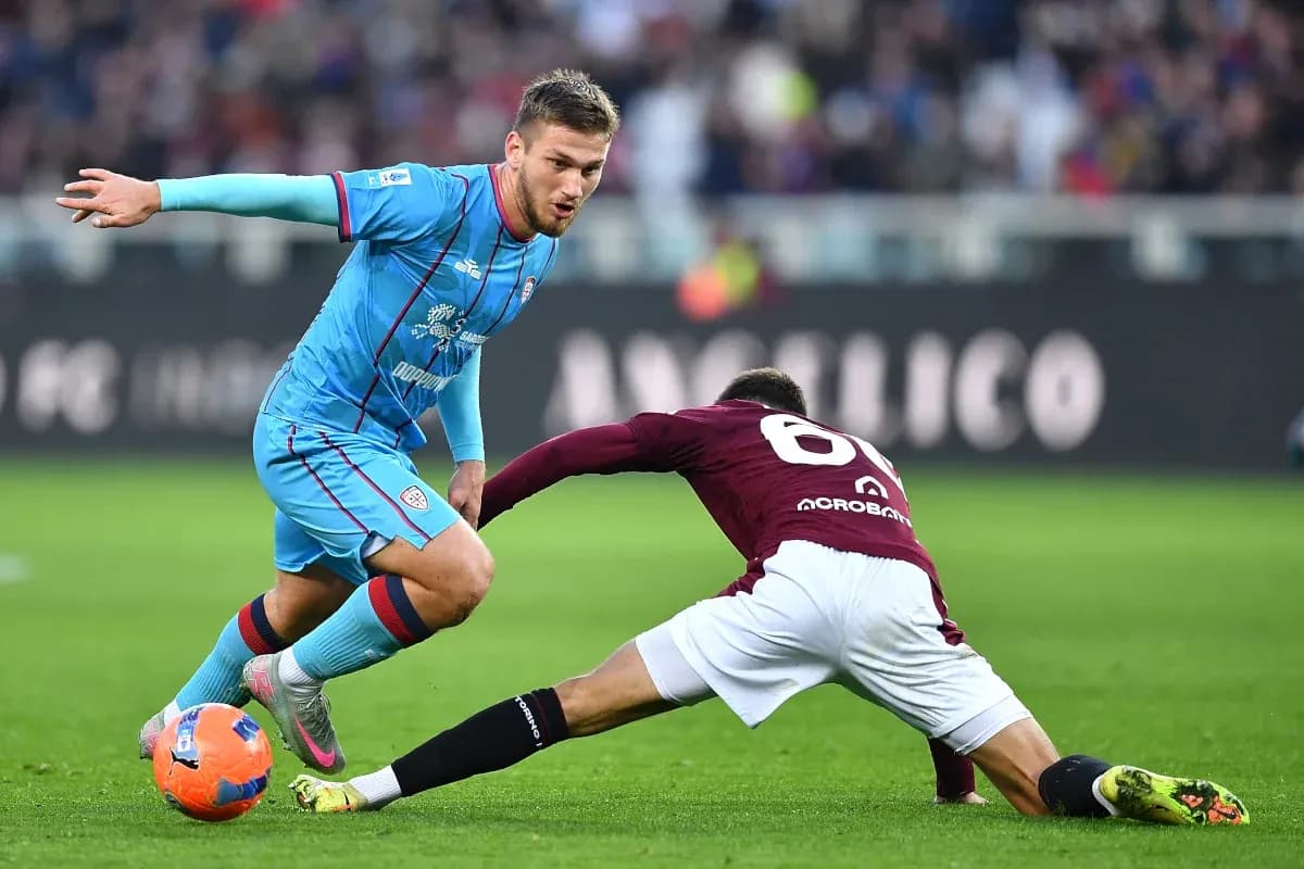 Cagliari player dribbling past Torino defender Cagliari player dribbling past Torino defender