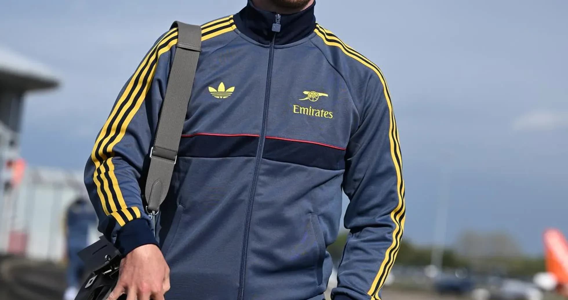 Athlete wearing tracksuit and cap walking outdoors Athlete wearing tracksuit and cap walking outdoors