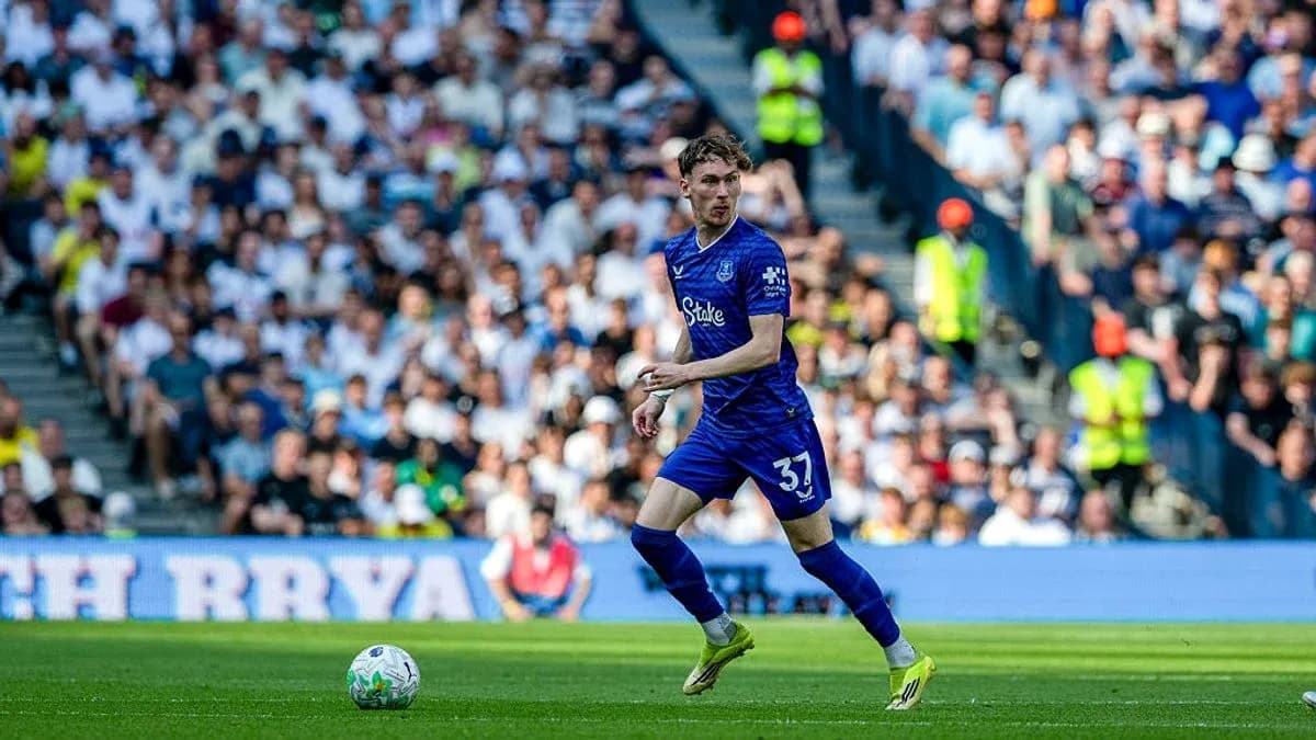 Player in blue jersey running with ball on field Player in blue jersey running with ball on field