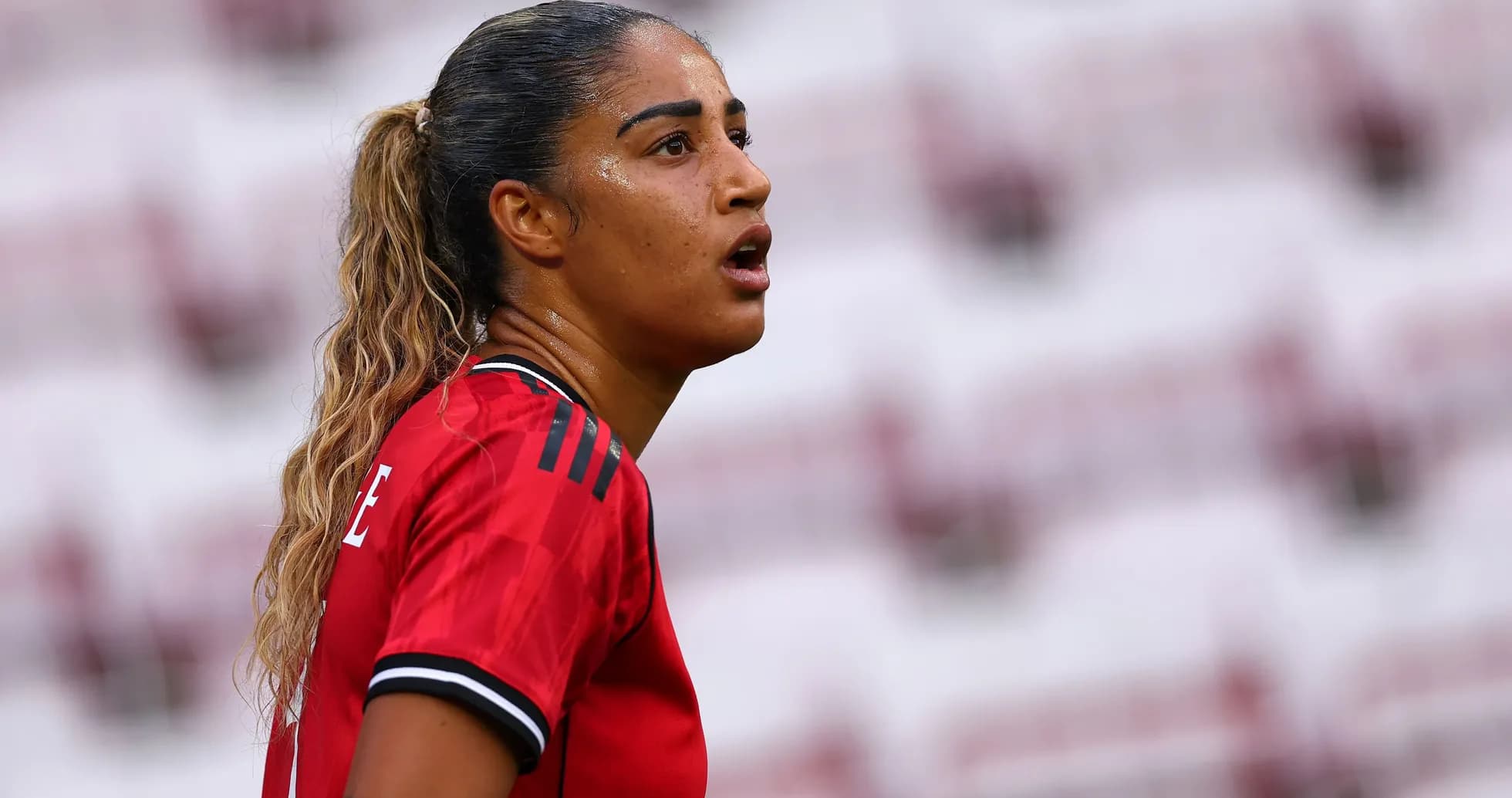 Female player in red jersey during match Female player in red jersey during match