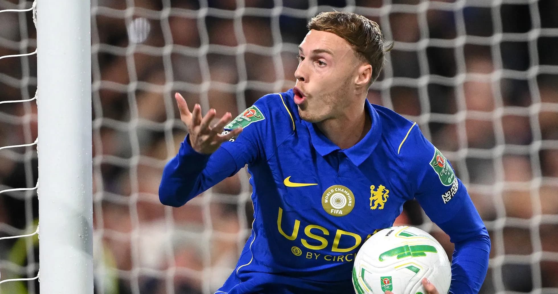 Player gesturing while holding the ball in goal Player gesturing while holding the ball in goal