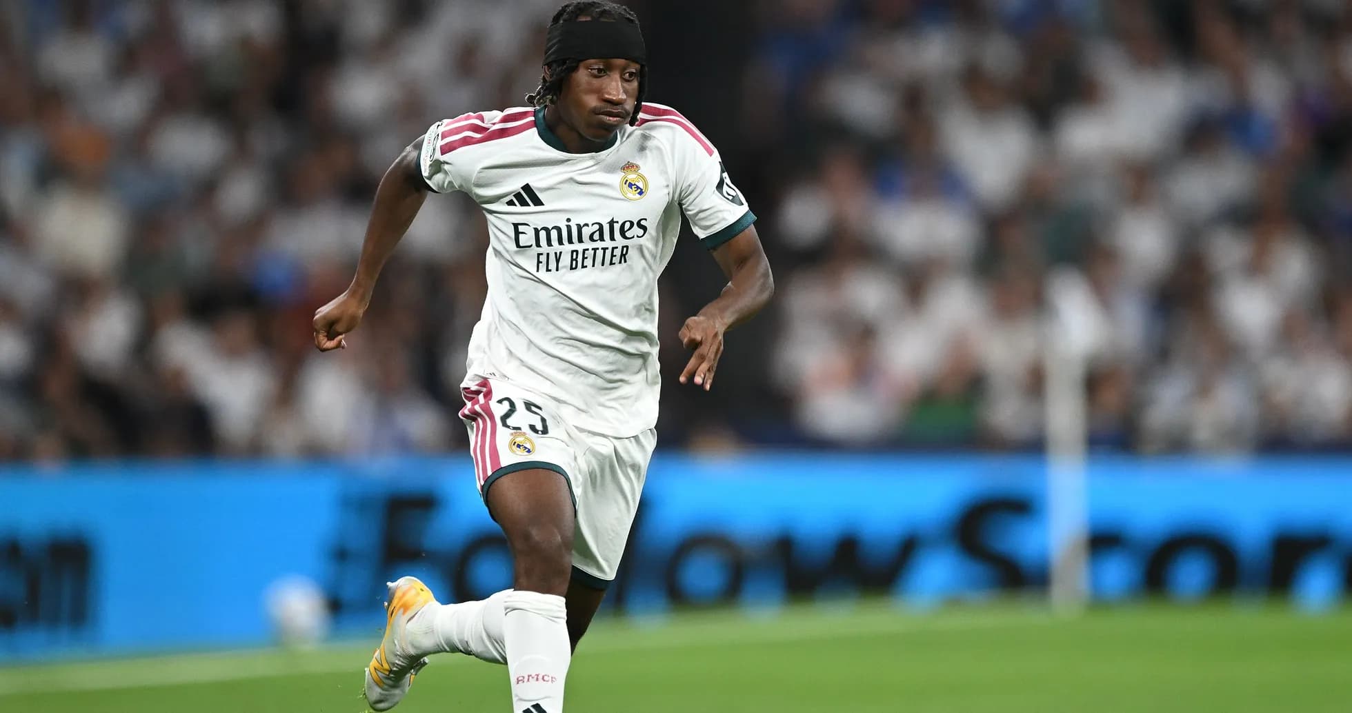 Player in Real Madrid kit running on the field Player in Real Madrid kit running on the field