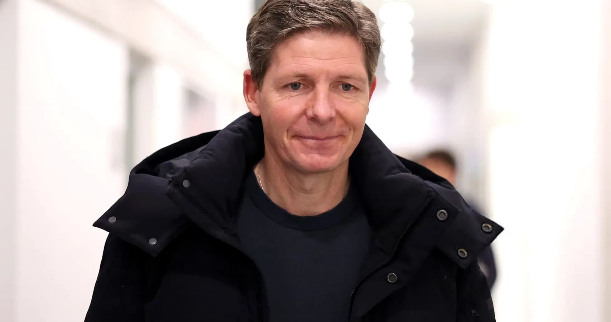 Man in a black jacket walking in hallway Man in a black jacket walking in hallway