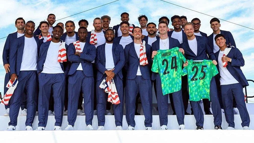 Soccer team posing in suits holding jerseys Soccer team posing in suits holding jerseys