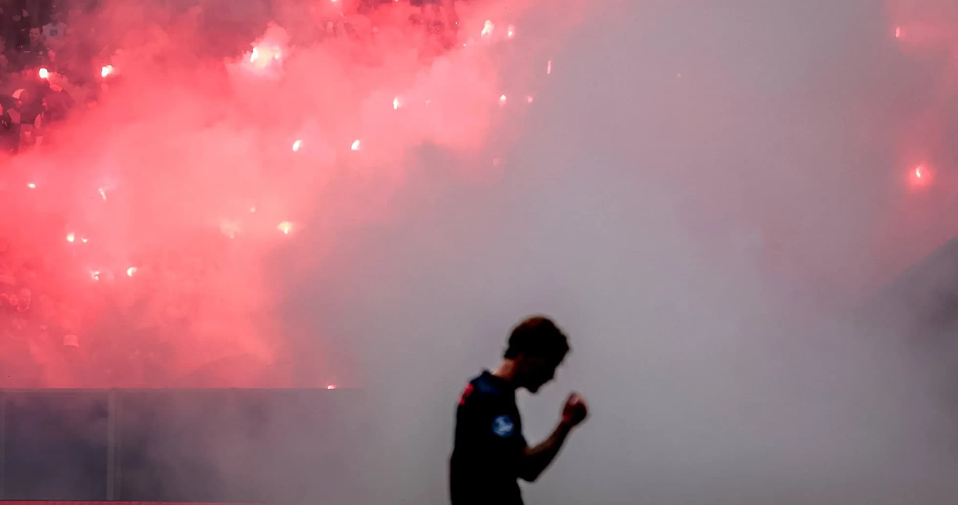 Player silhouetted against smoke and flares Player silhouetted against smoke and flares
