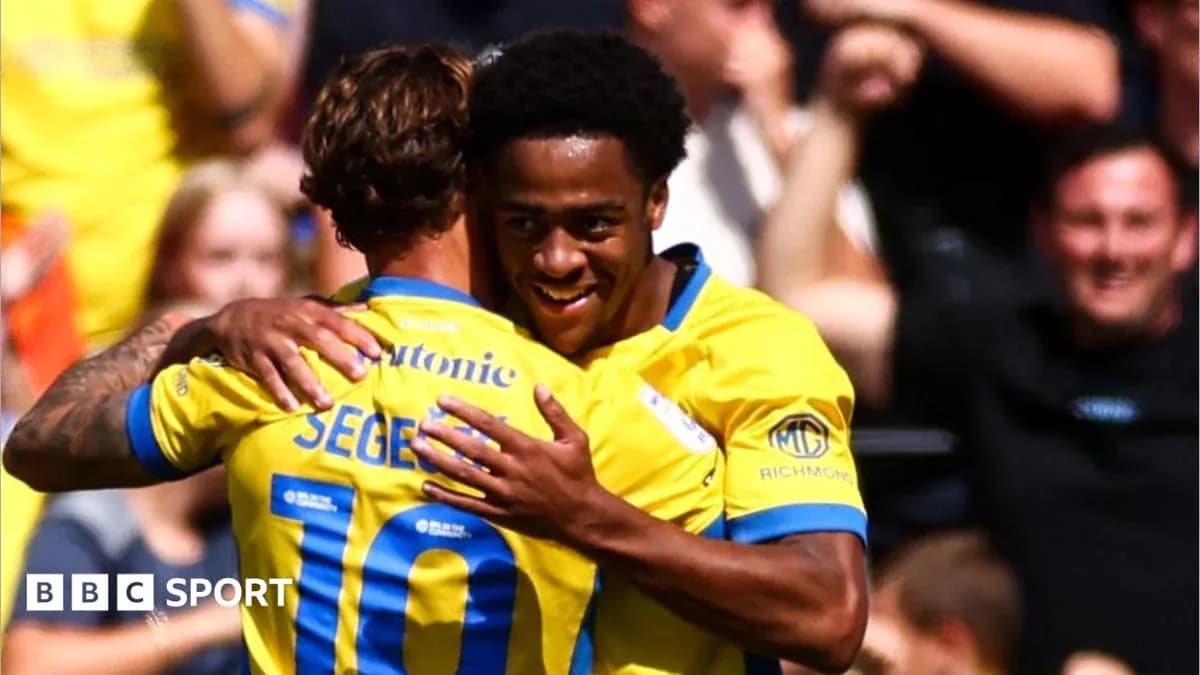 Two players celebrating a goal in yellow jerseys Two players celebrating a goal in yellow jerseys