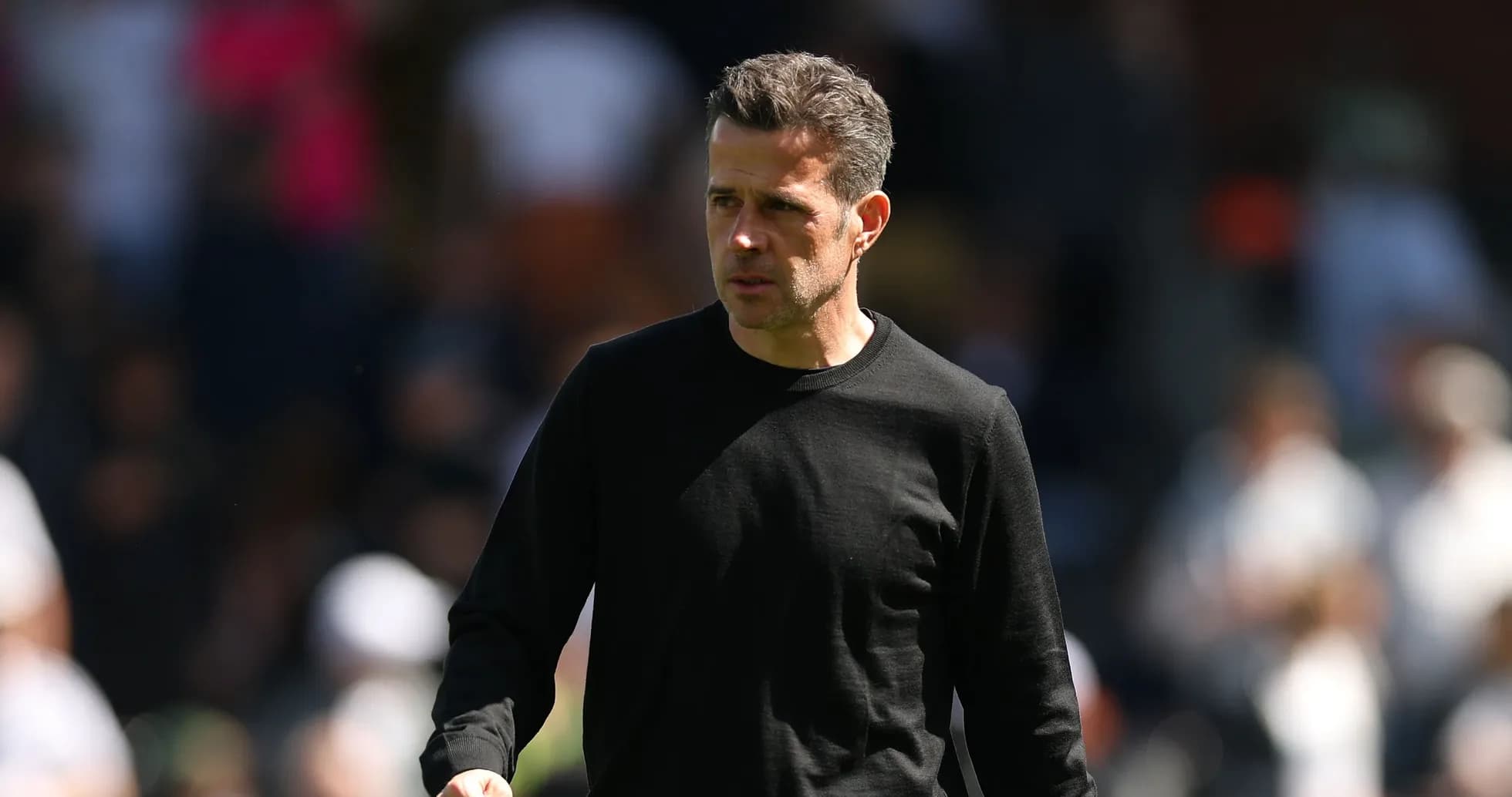 Coach walking on the pitch during a match Coach walking on the pitch during a match
