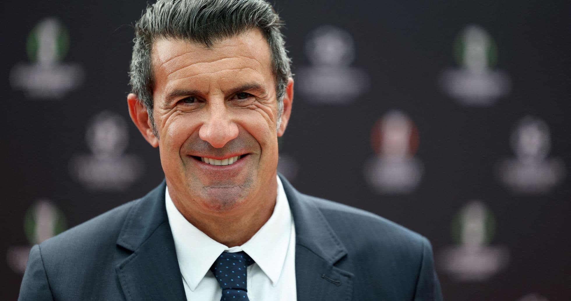 Smiling man in a suit at event backdrop Smiling man in a suit at event backdrop