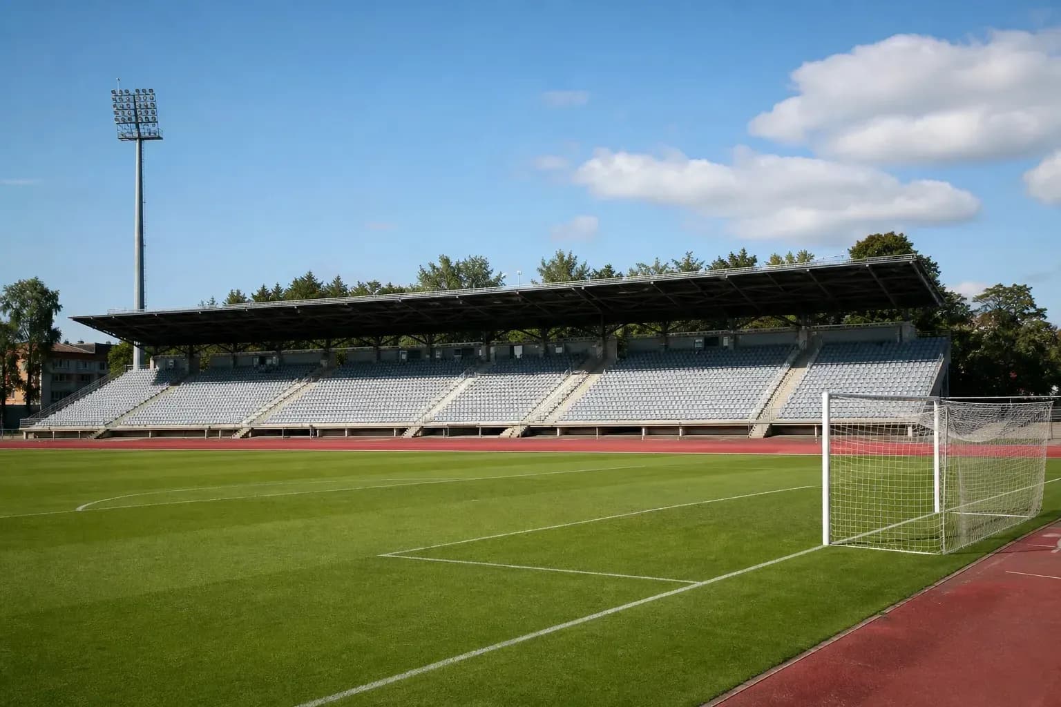 View of empty stadium with grass pitch and goal View of empty stadium with grass pitch and goal