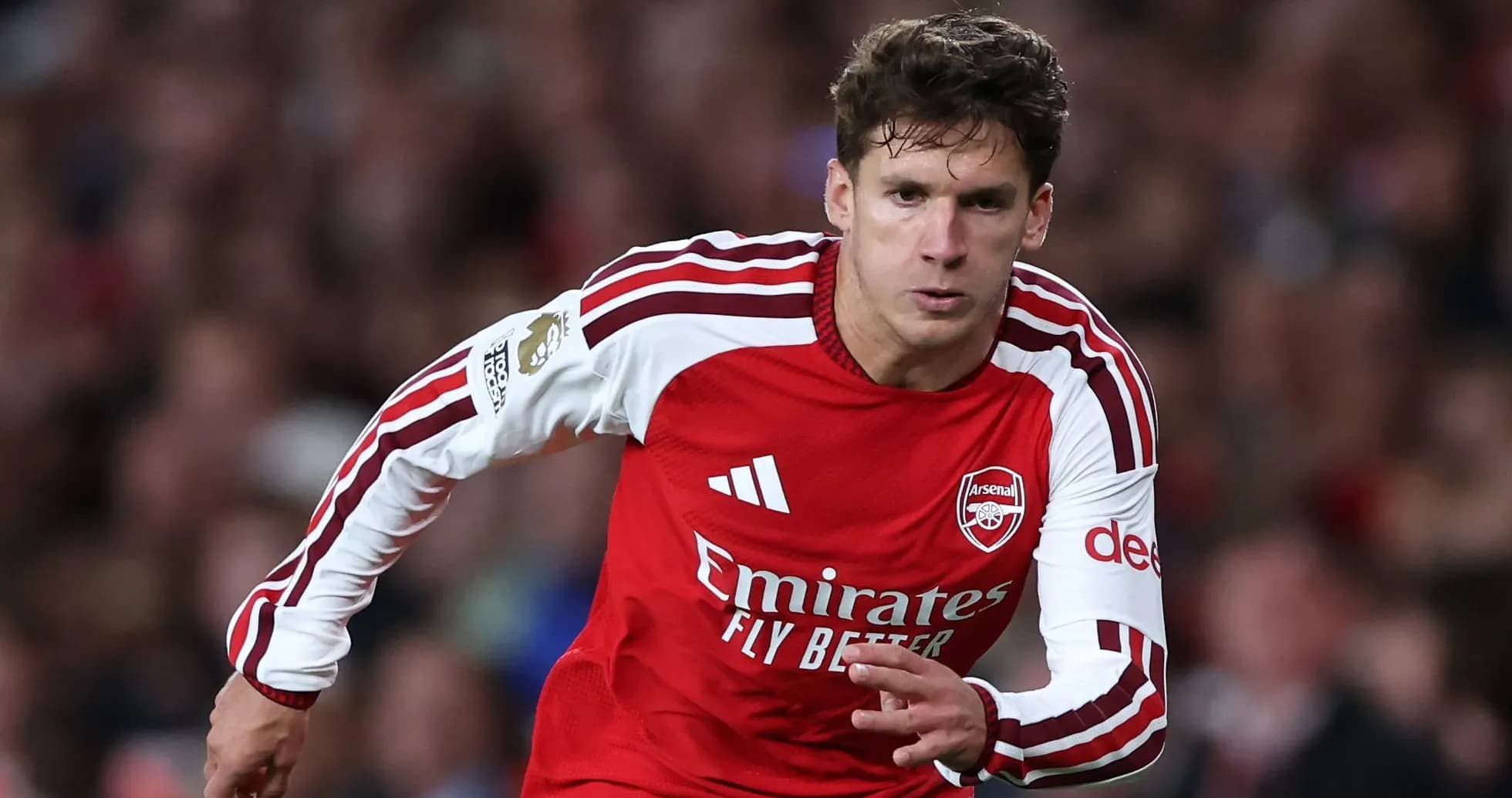 Player in Arsenal kit sprinting on the field Player in Arsenal kit sprinting on the field
