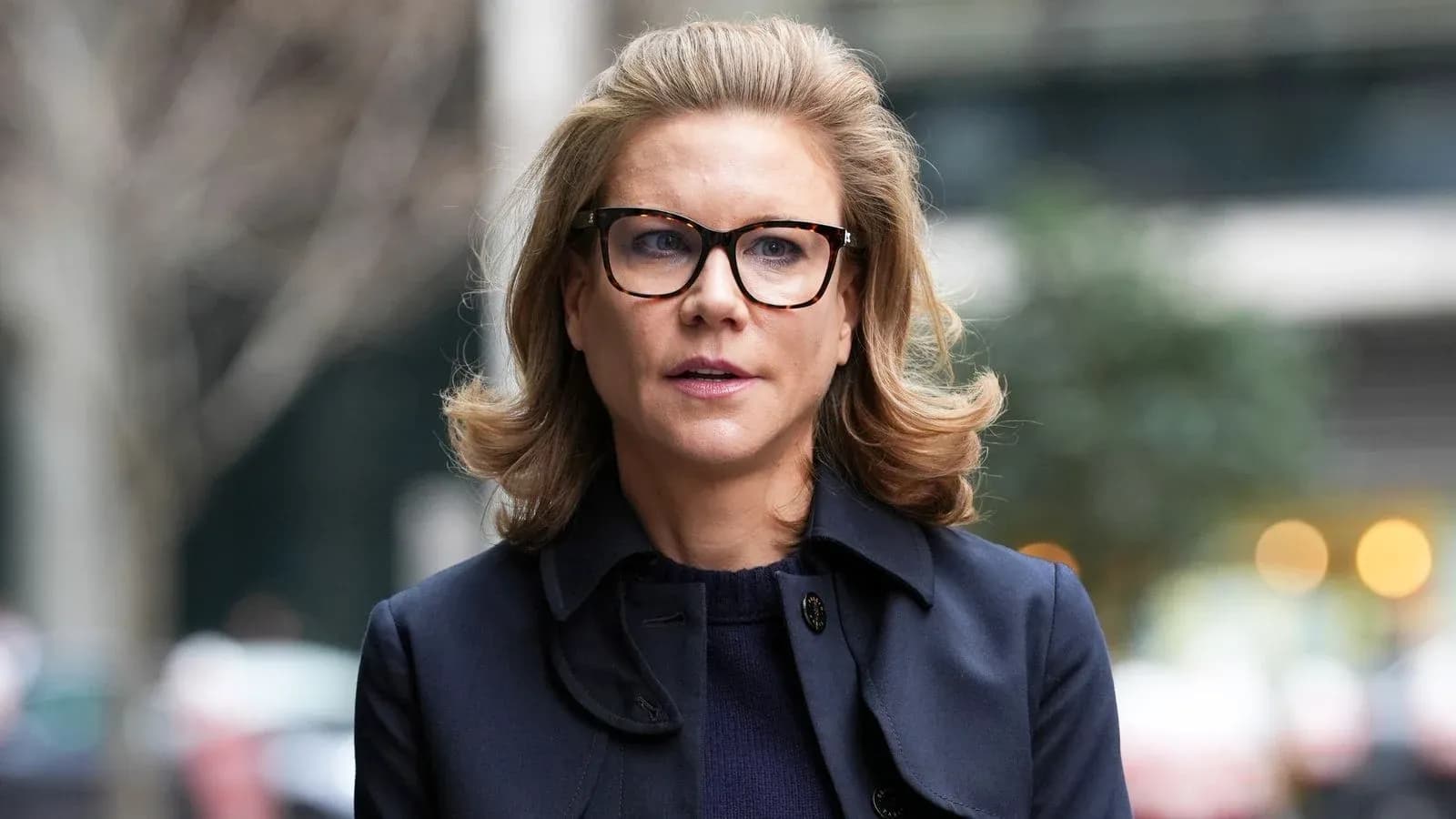 Woman with glasses walking outdoors in urban setting Woman with glasses walking outdoors in urban setting